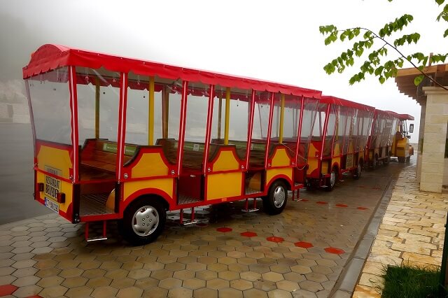 Turyści pociąg, którym przewożą do wejścia do jaskini